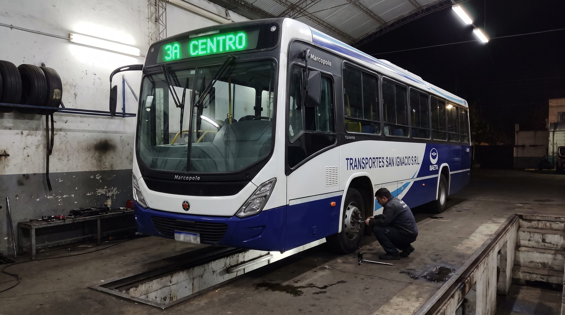 Mec&aacute;nico trabajando en una unidad sobre la fosa del taller